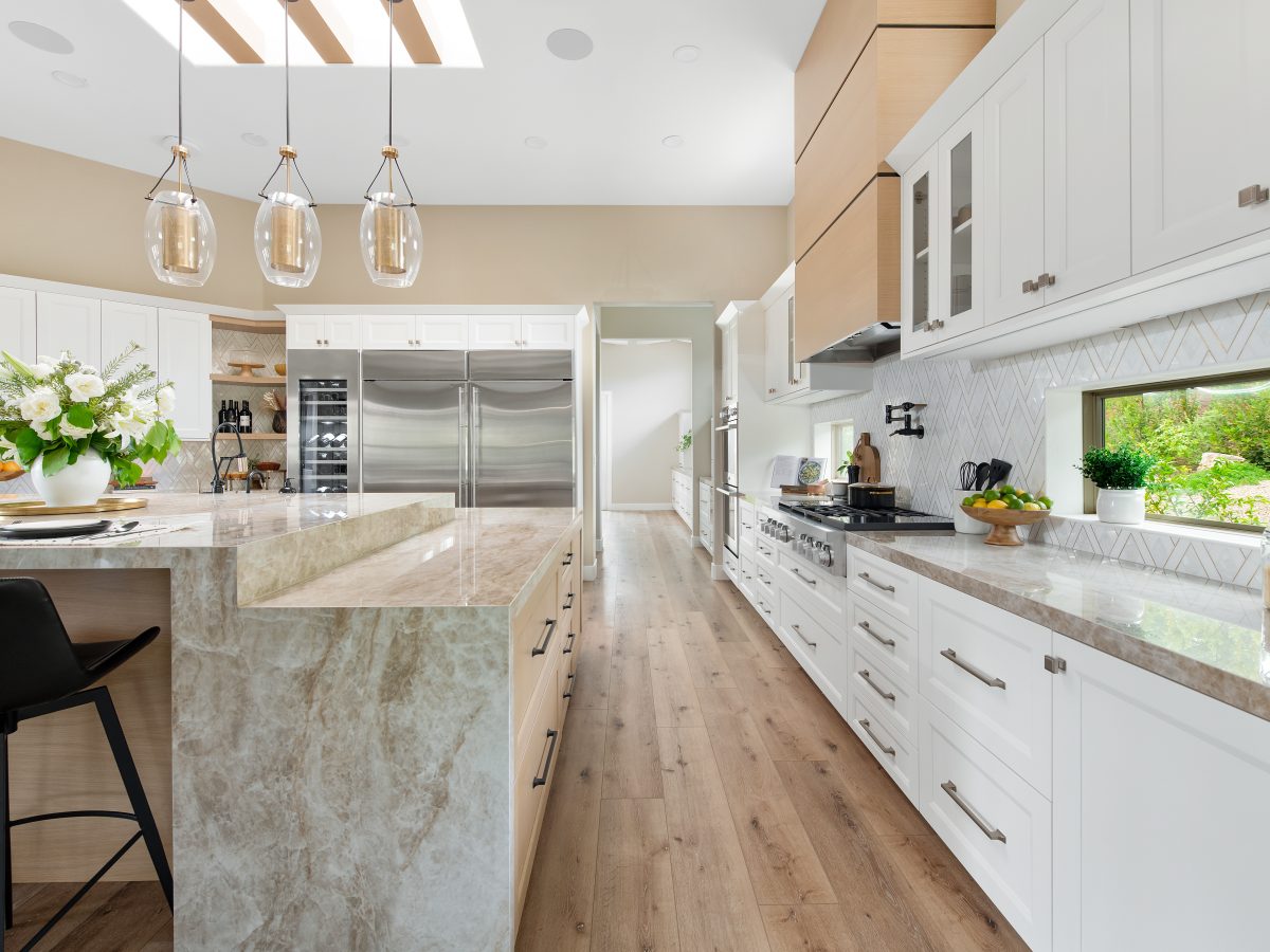 Luxury kitchen with Taj Mahal Dekton island, geometric stone backsplash, and brushed brass accents, Reveal Interior Design Las Vegas