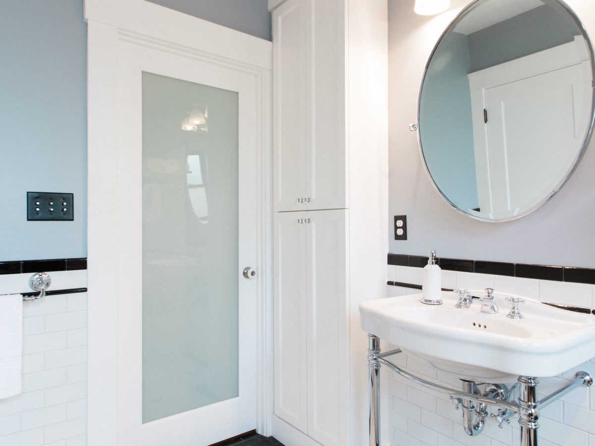 Historic 1920s black-and-white bathroom with hex mosaic floor and freestanding chrome sink, Reveal Interior Design Las Vegas