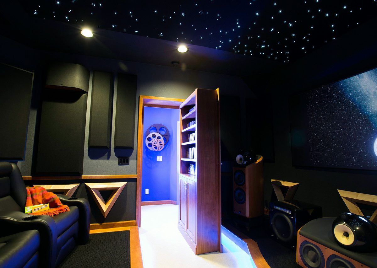 Home theater with fiber optic star ceiling, sound panels, and hidden maple bookcase door, Reveal Interior Design Las Vegas