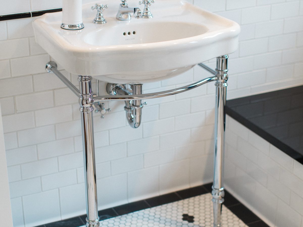 Classic black and white bathroom with hex mosaic floor and freestanding console sink, Reveal Interior Design Las Vegas