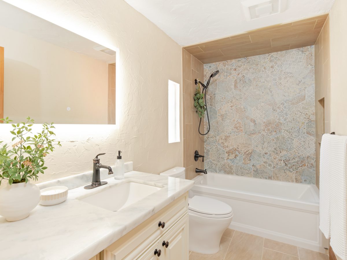 Modern Spanish-style guest bathroom with encaustic hex tile accent wall and oil-rubbed bronze fixtures, Reveal Interior Design Las Vegas