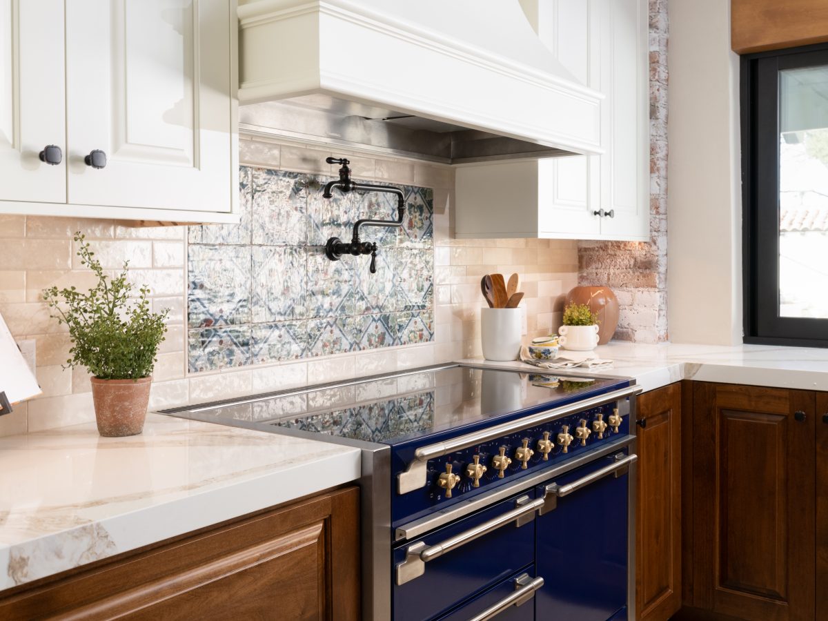 Spanish Modern kitchen with blue range, encaustic tile backsplash, and stained maple cabinetry, Reveal Interior Design Las Vegas