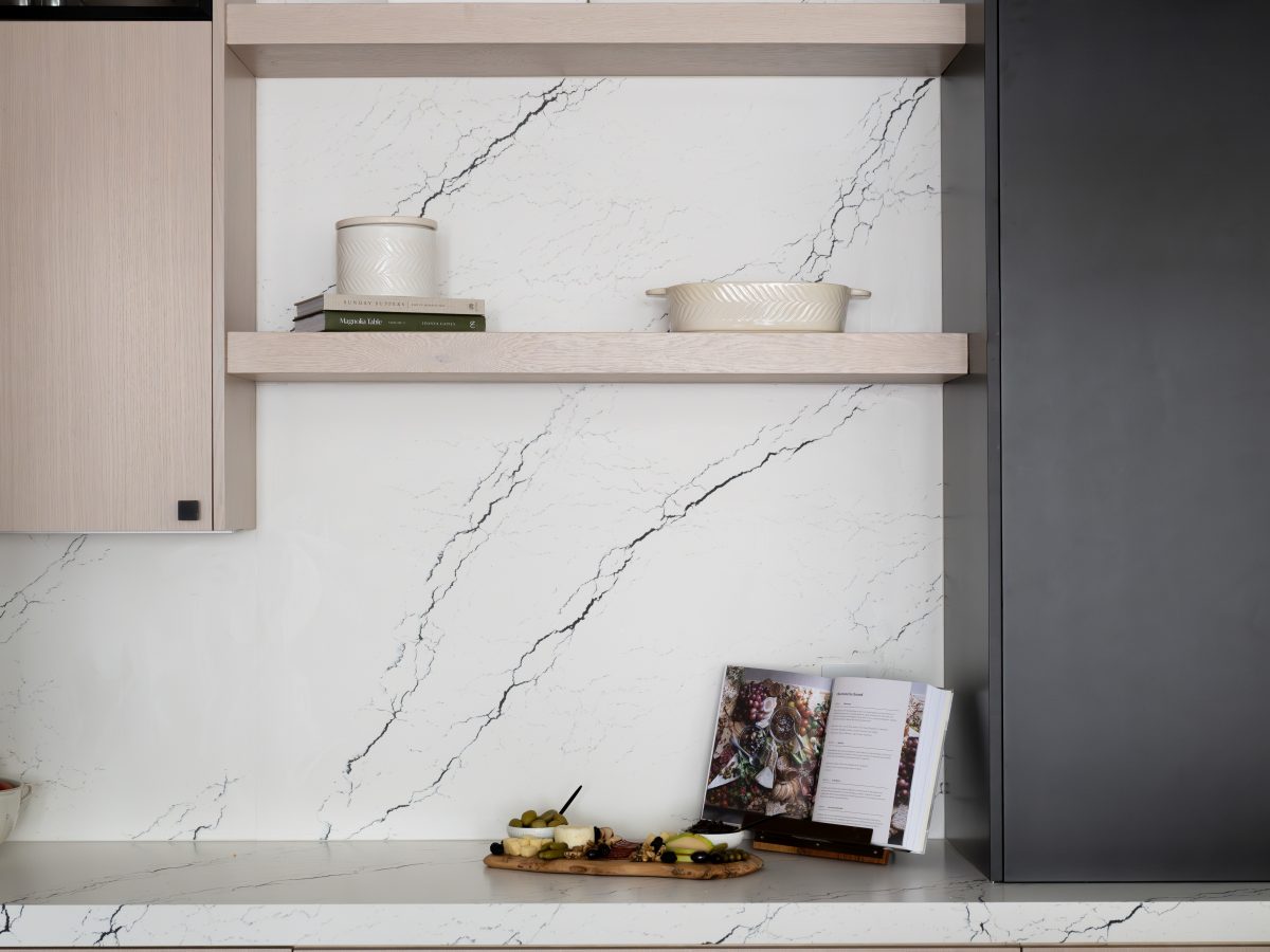 Kitchen floating shelves with white-washed oak cabinetry, matte black accents, and black-veined white quartz backsplash, Reveal Interior Design Las Vegas