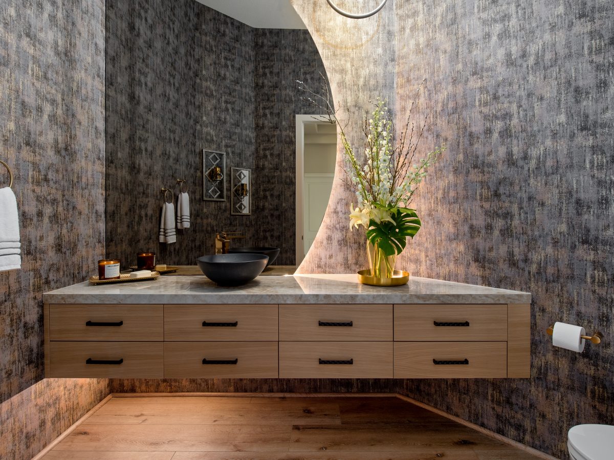 Powder room with floating white oak vanity, backlit moon mirror, and Taj Mahal Dekton countertop, Reveal Interior Design Las Vegas