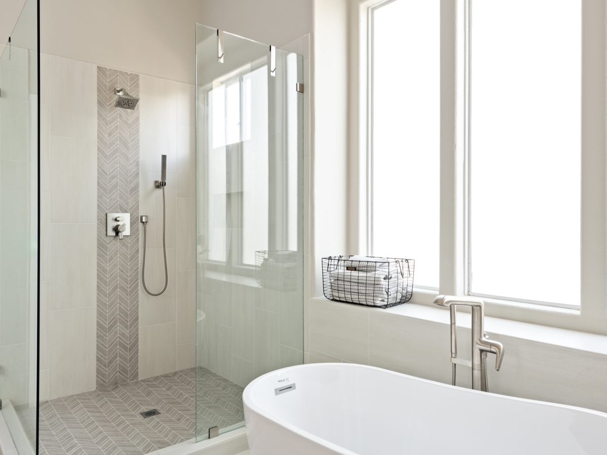 Primary bathroom with freestanding soaking tub, glass-enclosed shower, and porcelain tile, Reveal Interior Design Las Vegas