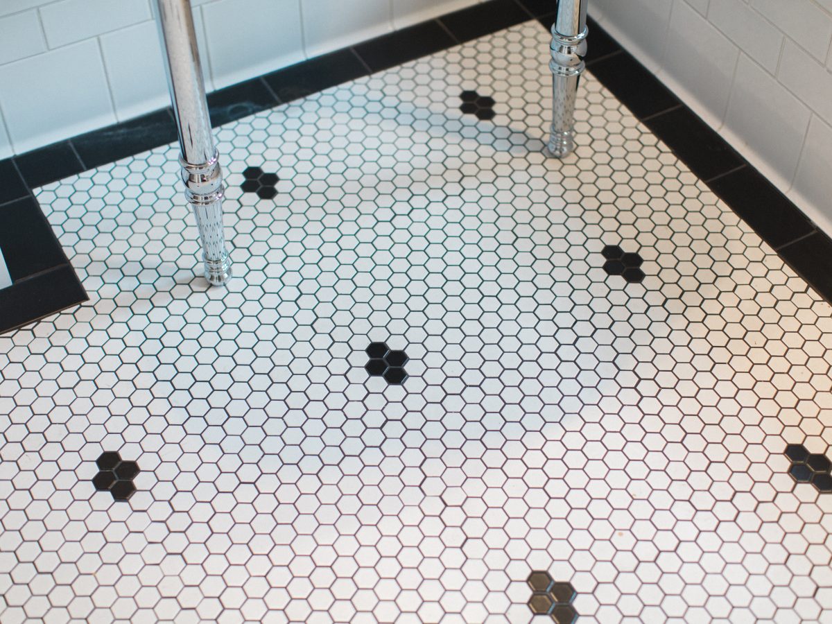 Bathroom hex mosaic floor with black accent tiles and chrome pedestal sink, Reveal Interior Design Las Vegas