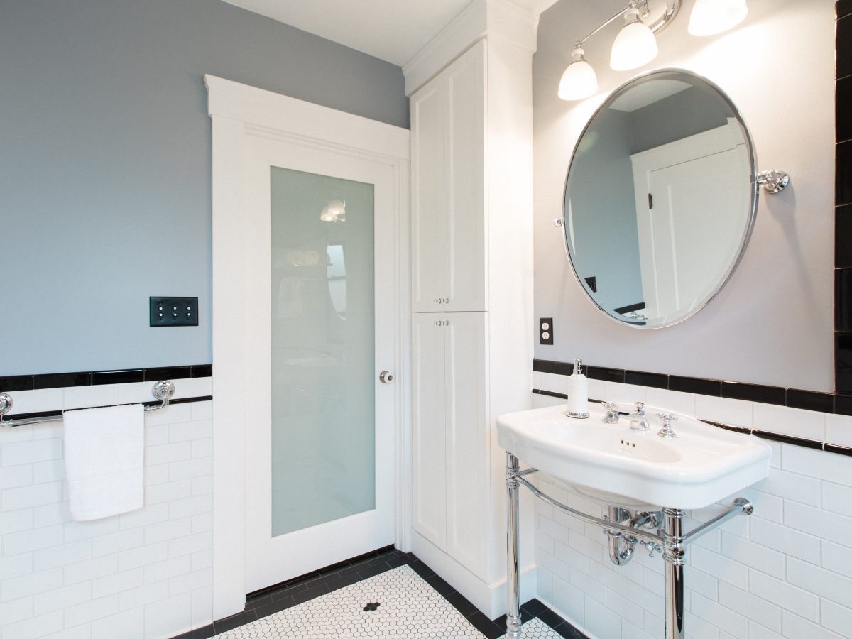 Historic black-and-white bathroom with hex mosaic floor and freestanding chrome sink, Reveal Interior Design Las Vegas