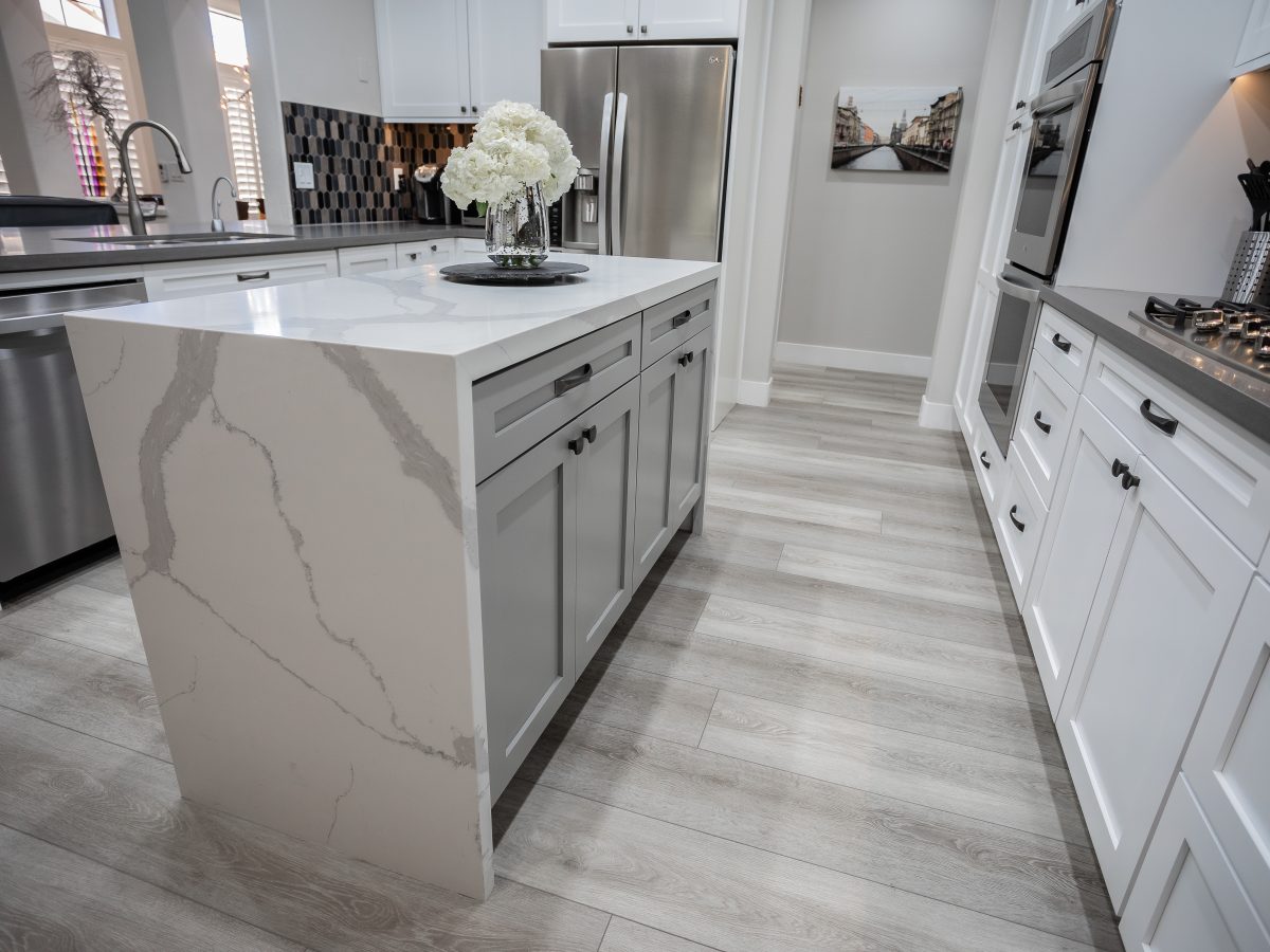 Transitional kitchen with Statuario-style quartz dual waterfall island and white shaker cabinetry, Reveal Interior Design Las Vegas