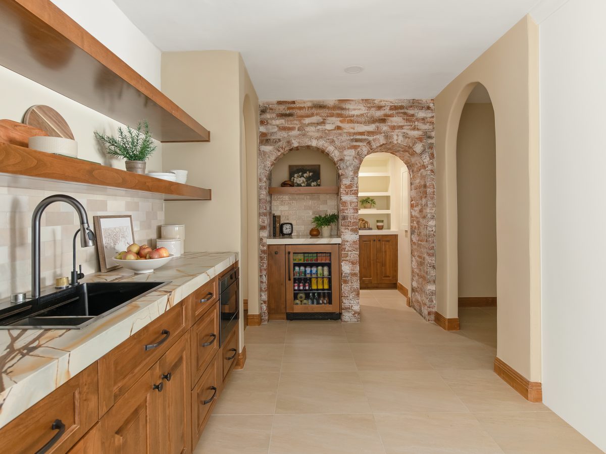 Spanish Modern prep sink station with whitewashed brick arches, stained maple cabinetry, and quartzite countertops, Reveal Interior Design Las Vegas