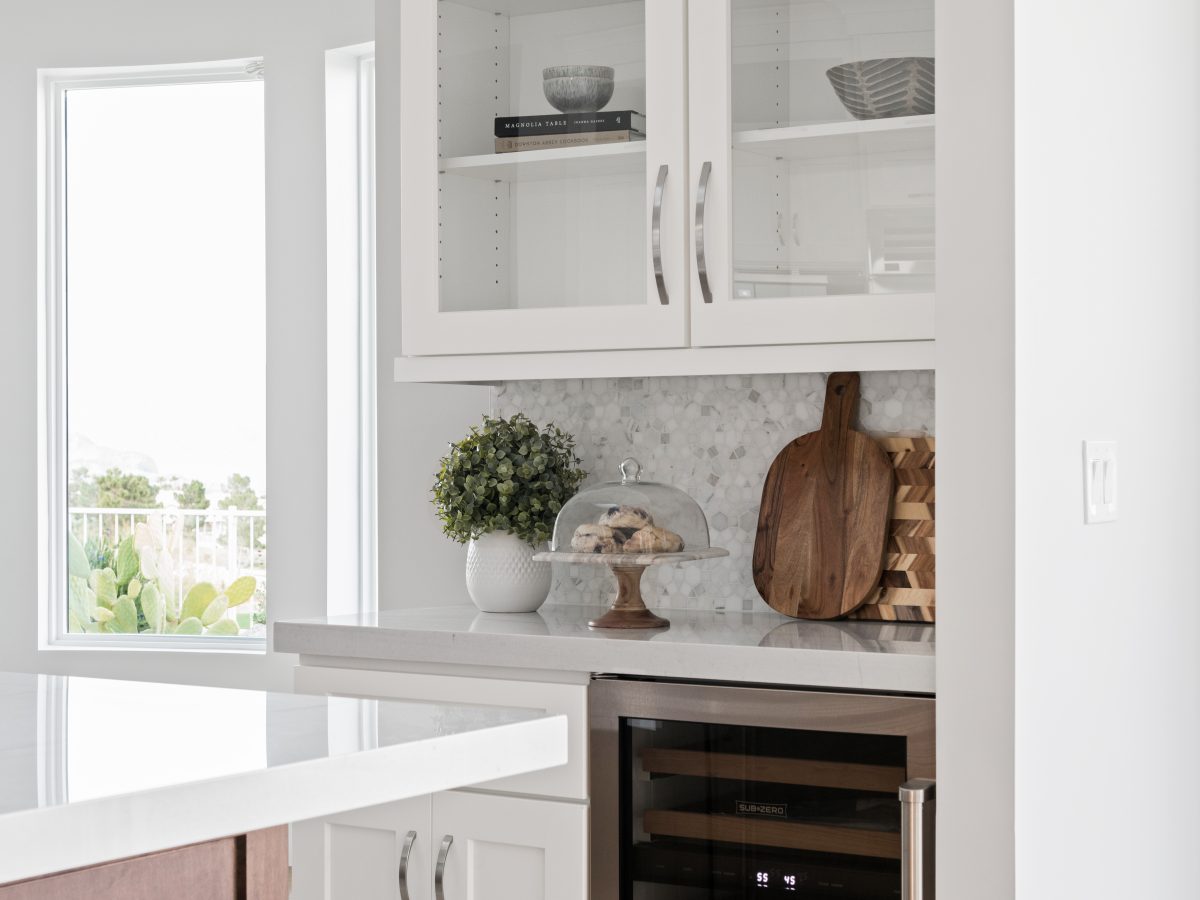 Transitional kitchen butler's pantry with Taj Mahal quartzite countertops and glass-front white cabinetry, Reveal Interior Design Las Vegas